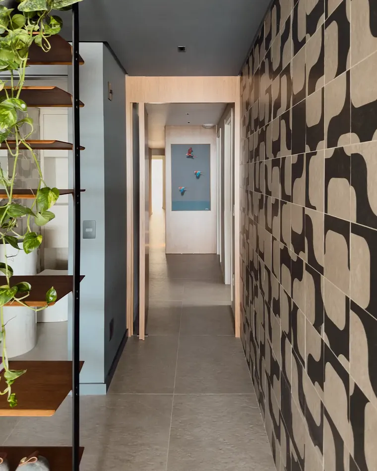Corredor com revestimento geométrico e marcenaria em apartamento reformado pela Schmidt