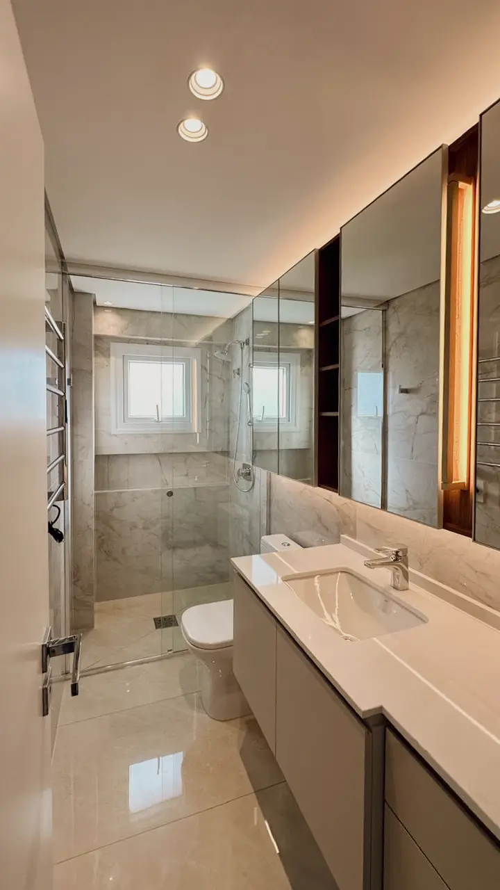Banheiro revestido em porcelanato marmorizado com box de vidro, entregue pela Schmidt